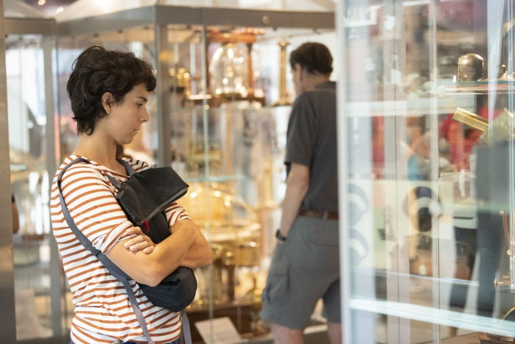 Woman looking at objects in a case at the Collection of Historical Scientific Instruments.