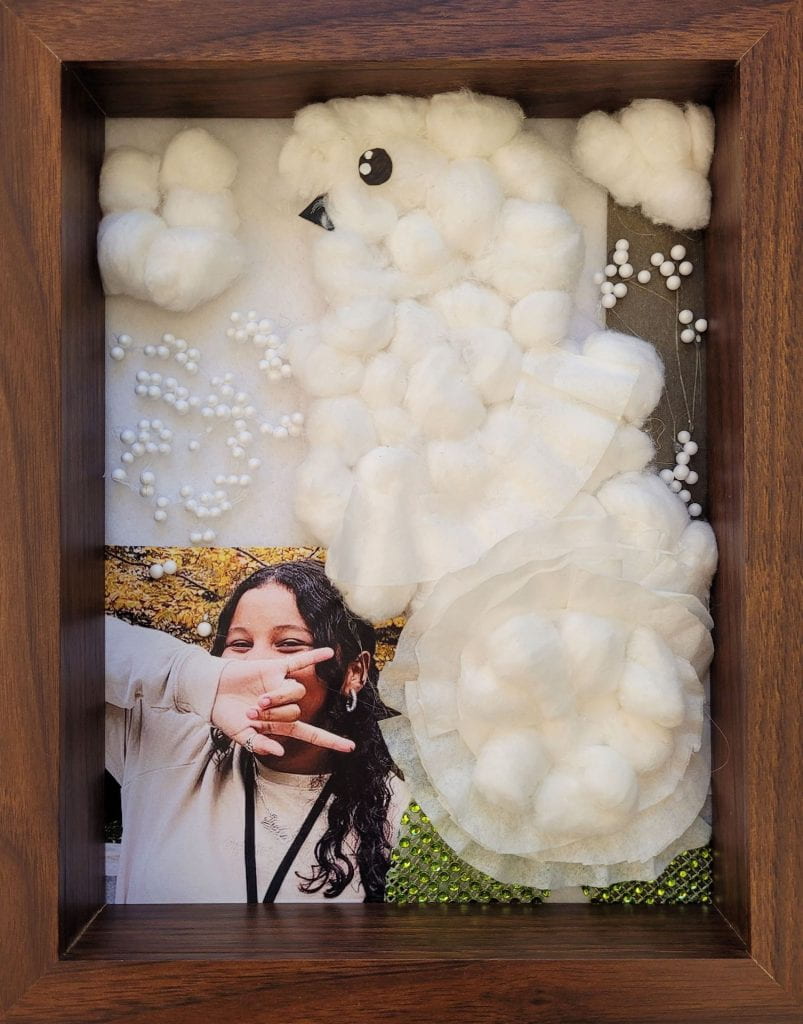 A snowy owl made of cotton balls, next to photograph of artist, Jadyn Silverio.