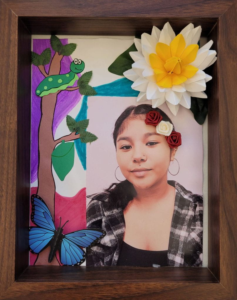 Catepillar, paper flower, and a butterfly surrounding the photograph of artist Cinthia Alvarado.