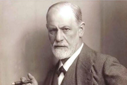 A black and white photo of Sigmund Freud holding a cigar.