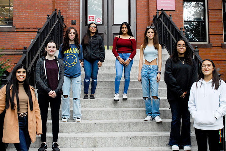 Eight latina high schoolers on the steps of the museum