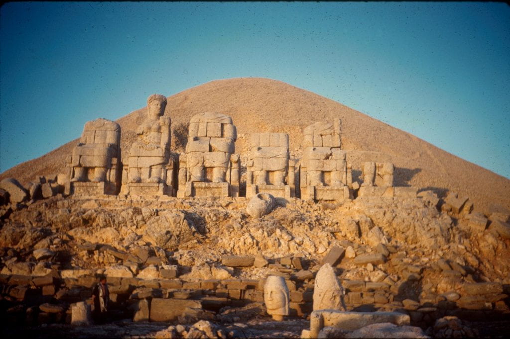 A large archaeological dig with stone statues in a desert.