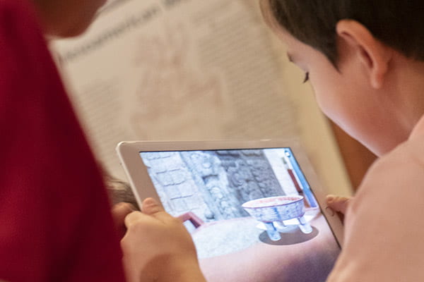 A child viewing the Augmented Reality Maya chocolate plate on a tablet device